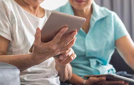 A patient talks to a UVA Health doctor on a tablet about needing a hip replacement