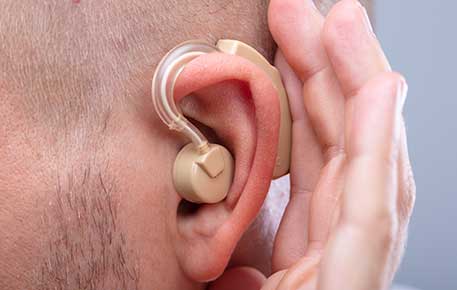 Adult man wearing a hearing implant on his ear.